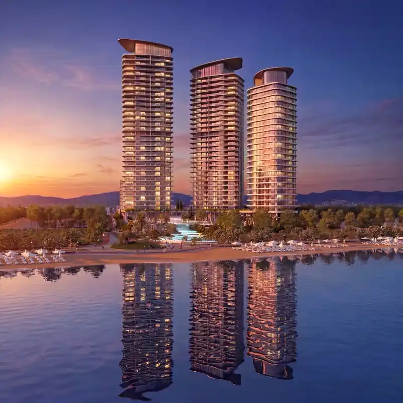 Three contemporary coastal residential towers reflected in the water at sunset