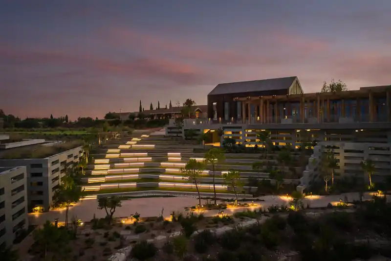 Mountain wellness resort with illuminated terraced landscaping at dusk